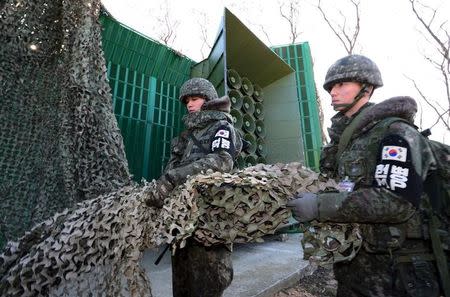 South Korean soldiers draw down a cover from loudspeakers, just south of the demilitarized zone separating the two Koreas, in Yeoncheon, South Korea, January 8, 2016. REUTERS/Korea Pool/Yonhap