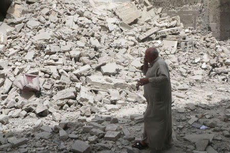 A man walks past the rubble of damaged buildings after an airstrike in the rebel held area of Aleppo's Baedeen district, Syria, May 3, 2016. REUTERS/Abdalrhman Ismail