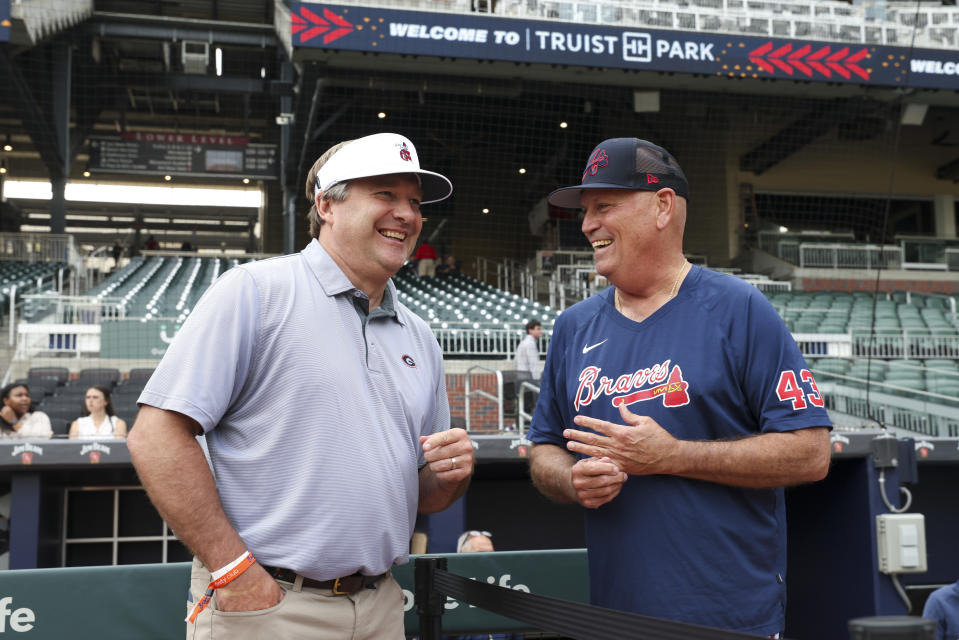 Georgia football coach Kirby Smart, left, talks with Atlanta Braves manager Brian Snitker before the Braves' baseball game against the Los Angeles Dodgers on Tuesday, May 23, 2023, in Atlanta. (Jason Getz/Atlanta Journal-Constitution via AP)