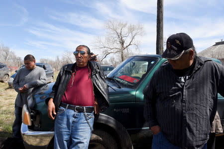 Dave Swallow (C), an elder and headsman of the Oglala Lakota Nation stands with Ivan Lookinghorse (R) and others on the Pine Ridge Reservation to discuss treaties and the treaty ride in Pine Ridge, South Dakota, U.S., April 22, 2018. REUTERS/Stephanie Keith