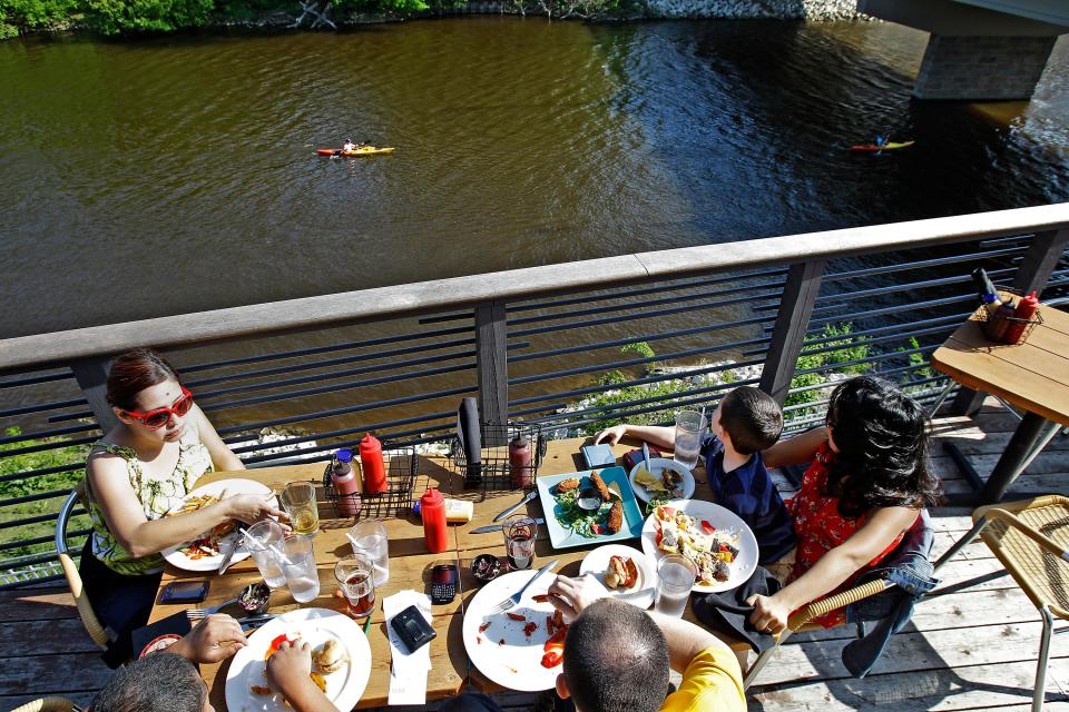 Victoria Escobedo (left) and Elizabeth and Levi Hoefle watch kayaks while dining from  a patio at Stubby's, 2060 N. Humboldt in Milwaukee Wednesday,  June 1, 2011.