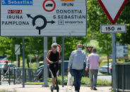 People cross the border between France and Spain at Behobie, southwestern France, Sunday, June 21, 2020. Spain reopened its borders to European tourists Sunday in a bid to kickstart its economy while Brazil and South Africa struggled with rising coronavirus infections. At a campaign rally, President Donald Trump said he told the U.S. government to reduce testing for the virus, apparently to avoid unflattering statistics ahead of the U.S. election in November. (AP Photo/Bob Edme)