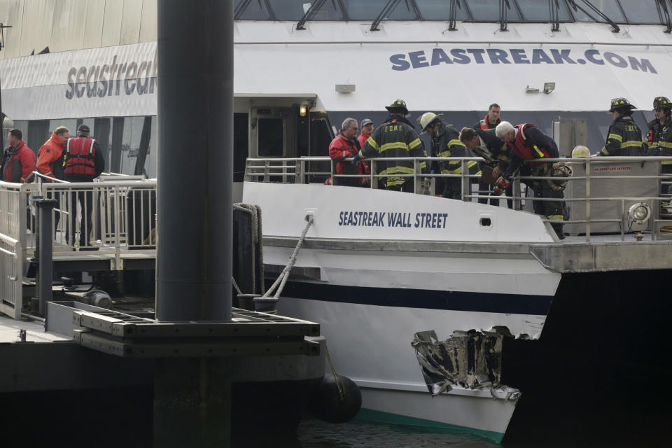 FILE - In this Jan. 9, 2013 file photo, New York City firefighters walk the deck of the Seastreak Wall Street ferry in New York, after the ferry banged into the mooring as it arrived from New Jersey to the South Street in lower Manhattan during morning rush hour, injuring more than 80 people. The National Transportation Safety Board is scheduled to meet on Tuesday, April 8, 2014, to discuss the 2013 accident involving the high-speed passenger ferry. Four of the 331 people on board the vessel sustained serious injuries. (AP Photo/Mark Lennihan, File)