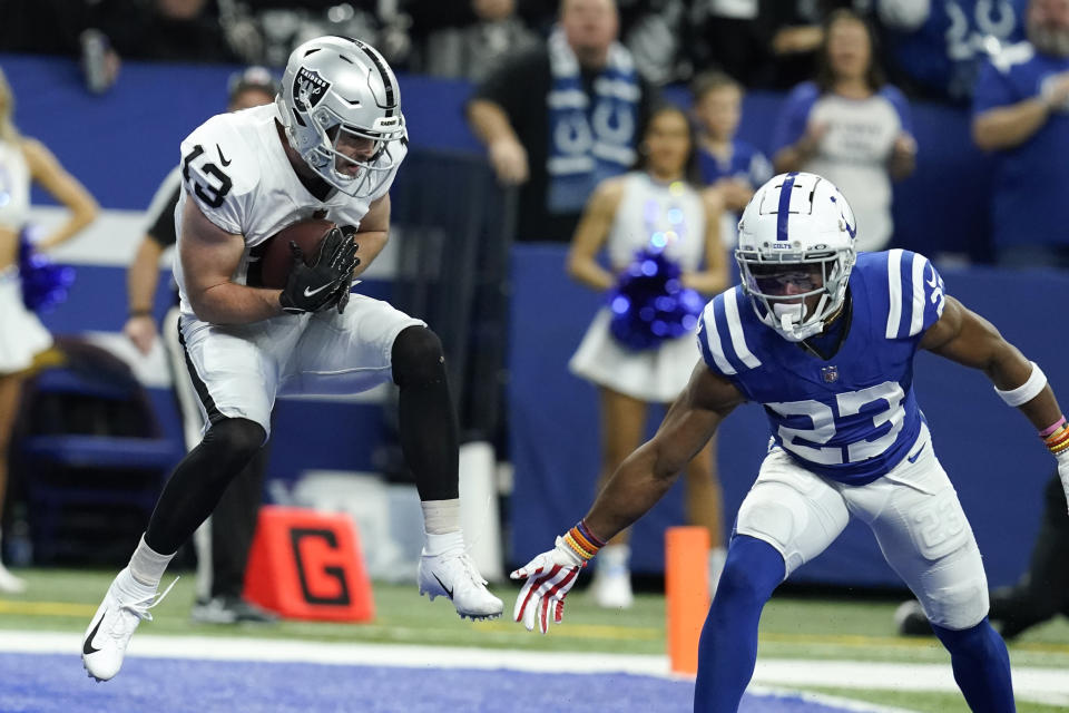 Las Vegas Raiders wide receiver Hunter Renfrow (13) catches an 11-yard touchdown pass ahead of Indianapolis Colts cornerback Kenny Moore II (23) during the second half of an NFL football game, Sunday, Jan. 2, 2022, in Indianapolis. (AP Photo/Darron Cummings)
