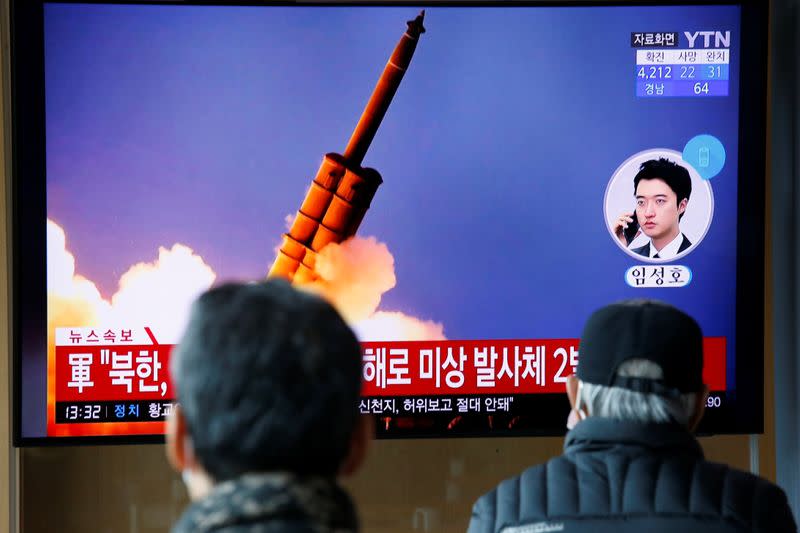 People watch a TV showing a file picture for a news report on North Korea firing two unidentified projectiles, in Seoul