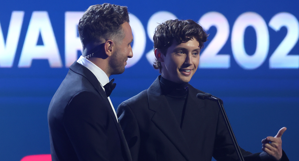 Tommy Little faces Troye Sivan in front of a microphone on the stage at the ARIAs