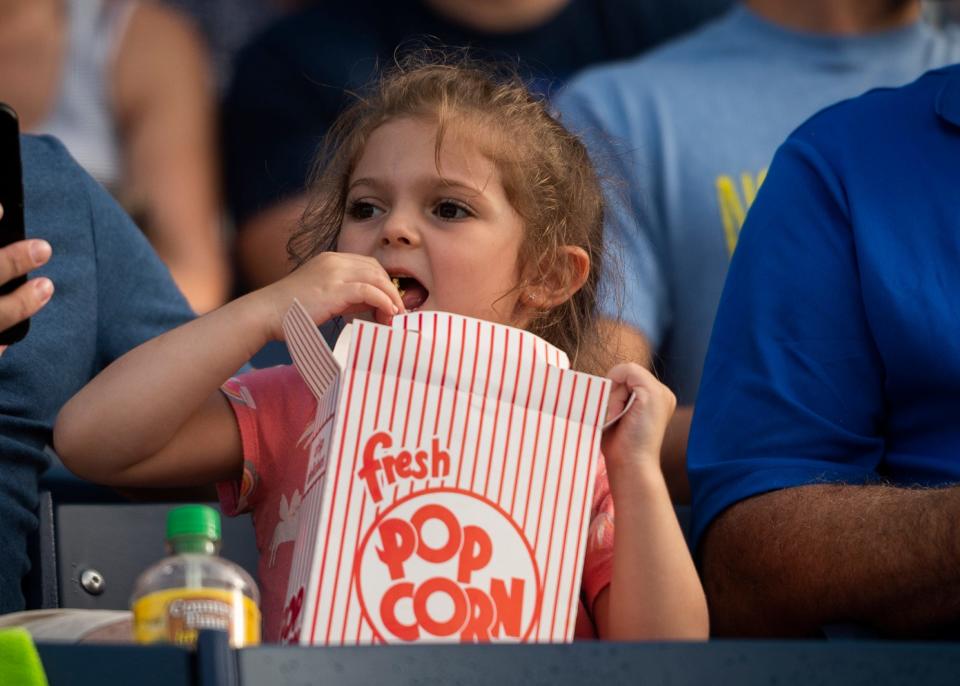 A young fan chows down on popcorn during a WooSox game.