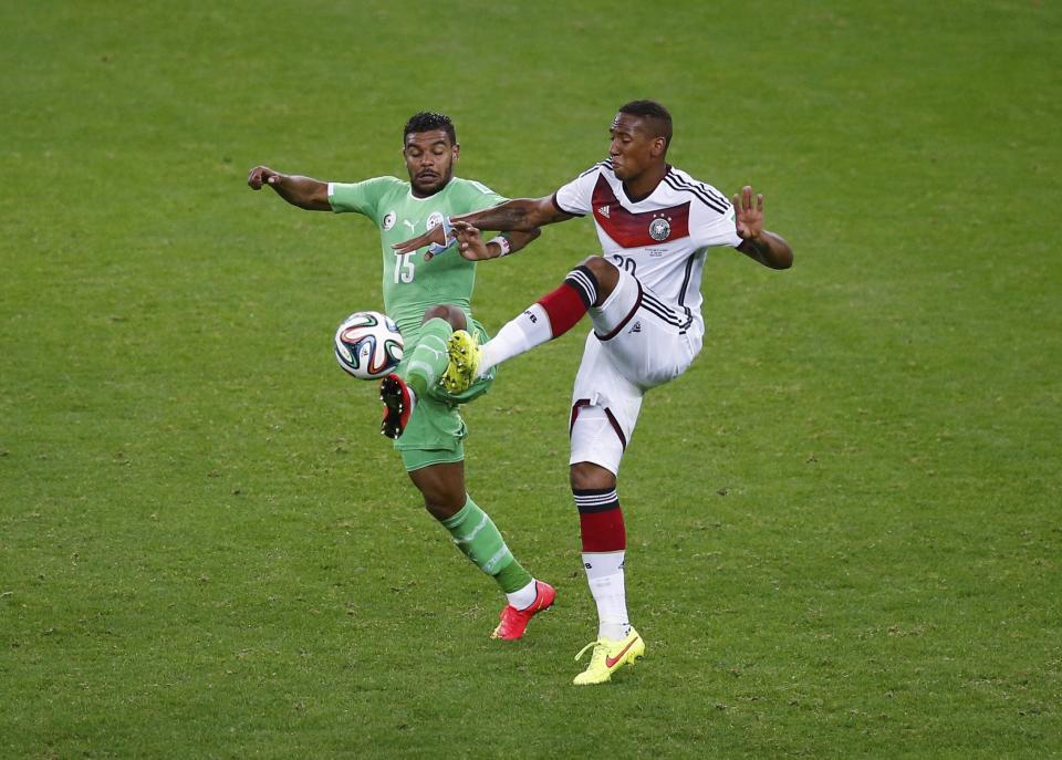 Algeria's El Arabi Soudani (L) fights for the ball with Germany's Jerome Boateng during their 2014 World Cup round of 16 game at the Beira Rio stadium in Porto Alegre June 30, 2014. REUTERS/Leonhard Foeger