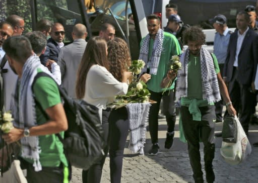 Palestinian women welcome Saudi Arabia's national football team with flowers