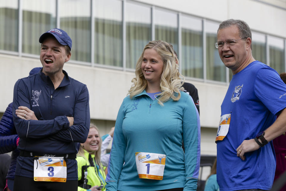 Berkshire Hathaway investment managers Todd Combs, left, Ted Weschler, right, and Tracy Britt Cool, Chairman of Berkshire companies Benjamin Moore, Johns Manville, Oriental Trading Company and Larson-Juhl, center, prepare to launch a 5K run sponsored by the Brooks Running Company. (AP Photo/Nati Harnik)