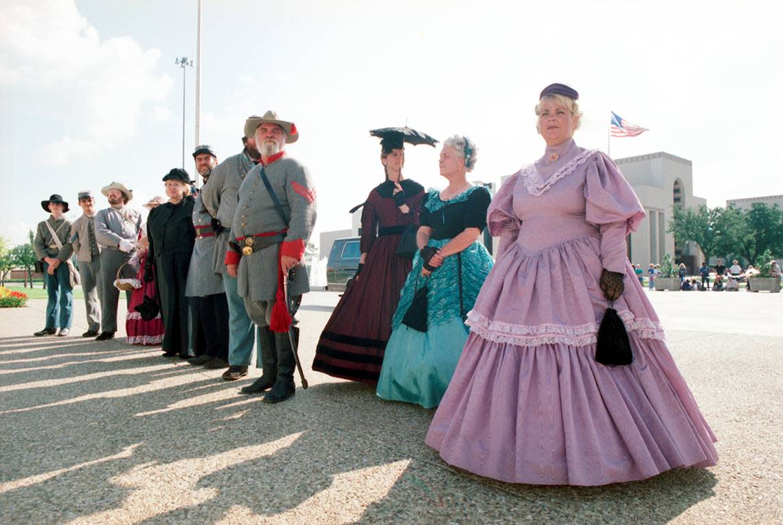 People dress in period attire are seen outside of the Hall of State in downtown Dallas in honor of Queen Elizabeth’s visit to Dallas.