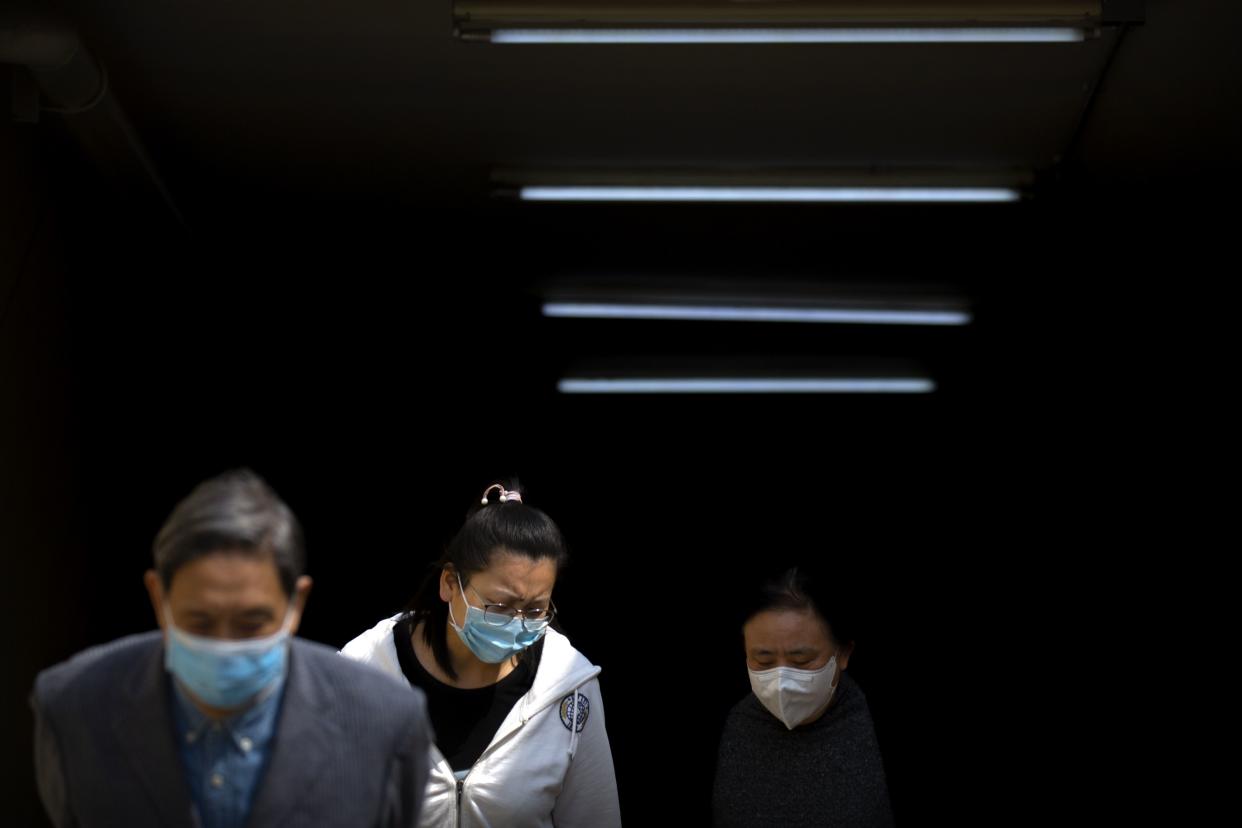 People wear face masks as they exit a subway station in Beijing, China on Tuesday, April 7, 2020. China on Tuesday reported no new deaths from the coronavirus over the past 24 hours and just 32 new cases, all from people who returned from overseas.