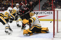 The puck flies past Pittsburgh Penguins goaltender Casey DeSmith (1) as Pierre-Olivier Joseph (73) and Ottawa Senators' Drake Batherson (19) watch during the second period of an NHL hockey game in Ottawa, on Saturday, Nov. 13, 2021. (Justin Tang/The Canadian Press via AP)