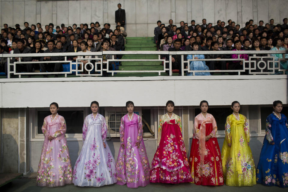 North Korean women in traditional dresses stand next to the running track inside Kim Il Sung Stadium during the running of the Mangyongdae Prize International Marathon in Pyongyang, North Korea on Sunday, April 13, 2014. The annual race, which includes a full marathon, a half marathon, and a 10-kilometer run, was open to foreign tourists for the first time this year. (AP Photo/David Guttenfelder)