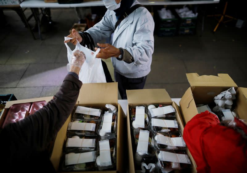 An elderly man receives food aid handouts, as the spread of the coronavirus disease (COVID-19) continues in Tokyo