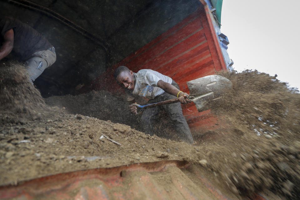 FILE - Farmers offload livestock manure from a truck, that will be used to fertilize crops due to the increased cost of fertilizer that they say they now can't afford to purchase, in Kiambu, near Nairobi, in Kenya, March 31, 2022. It's been six months since Russia invaded Ukraine, and the consequences are posing a devastating threat to the global economy. Governments, businesses and families worldwide are feeling the effects just two years after the coronavirus pandemic ravaged global trade. (AP Photo/Brian Inganga, File)