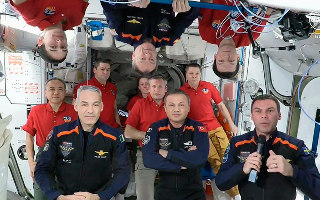 The ISS crew members representing Expedition 70 (red shirts) and Axiom Space 3 (dark blue) gather for a farewell ceremony calling down to mission controllers on Earth on Feb 2. Front row are Italy's Walter Villadei, Turkey's Alper Gezeravci and Sweden's Marcus Wandt. Above them hanging upside down in blue is Axiom Space's Michael Lopez-Alegria, a former Nasa astronaut