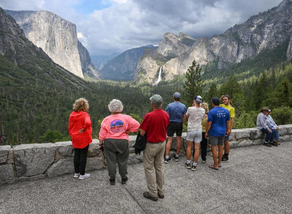Yosemite National Park visitors take a look at El Capitan rock formation, left, and Bridalveil Fall from Tunnel View in Yosemite Valley on Tuesday, June 14, 2023.