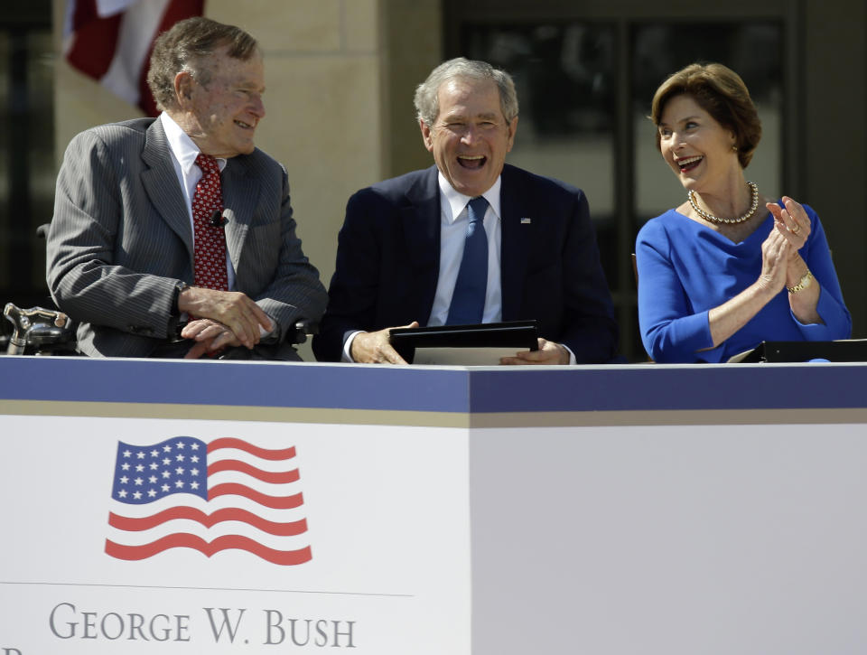 Former President George W. Bush, center, shares a laugh with his wife, former first lady Laura Bush and father, former President George H.W. Bush during the dedication of the George W. Bush presidential library on Thursday, April 25, 2013, in Dallas. (AP Photo/David J. Phillip)