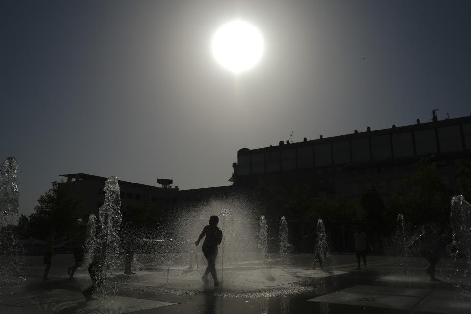 A child cools off with the water to the fountain during a heatwave in Pamplona, northern Spain, Aug. 13, 2021. Stifling heat gripped much of Spain and Southern Europe. (AP Photo/Alvaro Barrientos)