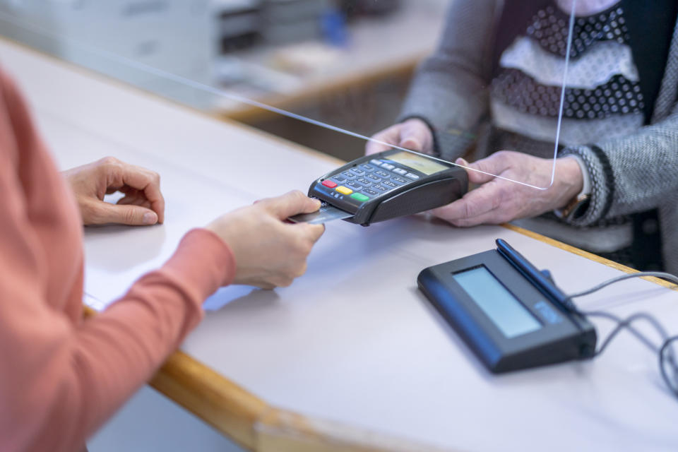 A person paying with a credit card at a register