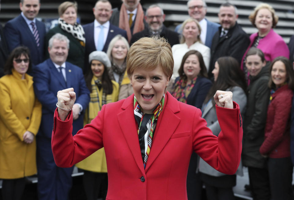 Scottish First Minister Nicola Sturgeon poses with newly elected MPs of Scottish National Party (SNP) during a photo opportunity as they gather outside the V&A Museum in Dundee, Scotland, Saturday Dec. 14, 2019.  Sturgeon delivered a landslide election victory for the SNP, with a campaign focused on demands for a second referendum on Scottish independence, but Prime MinisterBoris Johnson has flatly rebuffed the idea of another vote. (Andrew Milligan/PA via AP)