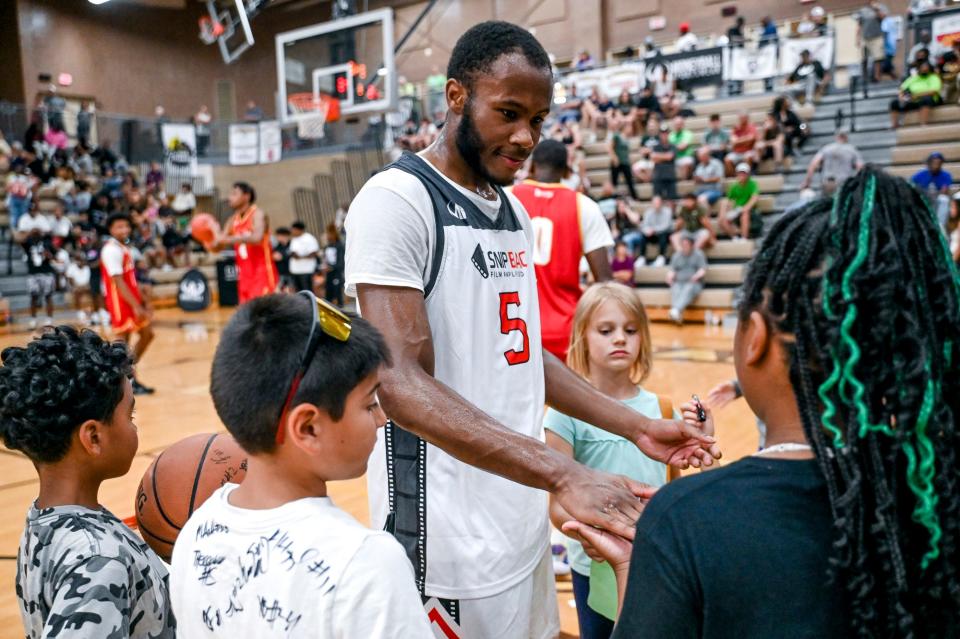 Michigan State's Tre Holloman visits with young fans on Thursday, June 29, 2023, during the Moneyball Pro-Am at Holt High School.