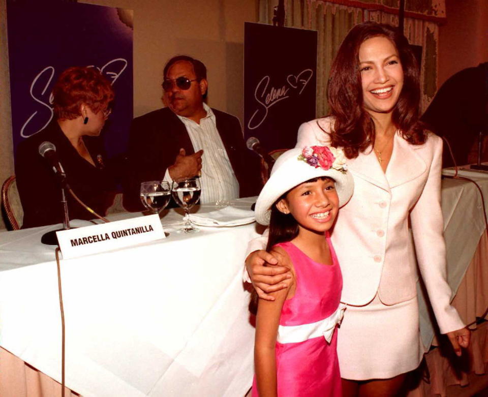 Becky Lee Meza (izquierda), a los 9 años de edad, y Jennifer López (derecha) durante la conferencia de prensa en Beverly Hills, 1que las presentó al mundo como las intérpretes de Selena Quintanilla, al fondo, se pueden apreciar Marcella y Abraham, los padres de la fallecida cantante. (Getty Images)