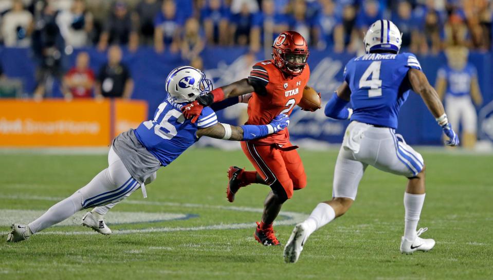 Utah running back Zack Moss (2) carries the ball as BYU's Sione Takitaki (16) and Fred Warner (4) defend, Sept. 9, 2017.
