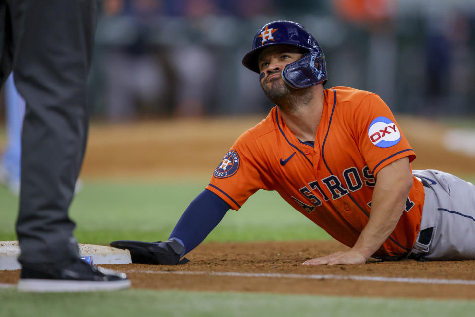 Houston Astros' Jose Altuve dives back to first in the seventh inning of a baseball game against the Texas Rangers, Sunday, July 2, 2023, in Arlington, Texas. (AP Photo/Gareth Patterson)