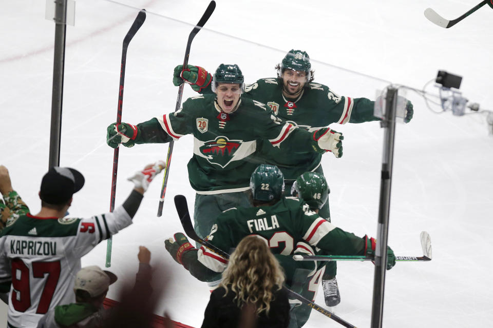 Minnesota Wild left wing Kevin Fiala (22) is congratulated by Joel Eriksson Ek (14) and Mats Zuccarello (36) after scoring a goal against the Vegas Golden Knights during the third period in Game 6 of an NHL hockey Stanley Cup first-round playoff series Wednesday, May 26, 2021, in St. Paul, Minn. The Wild won 3-0. (AP Photo/Andy Clayton-King)