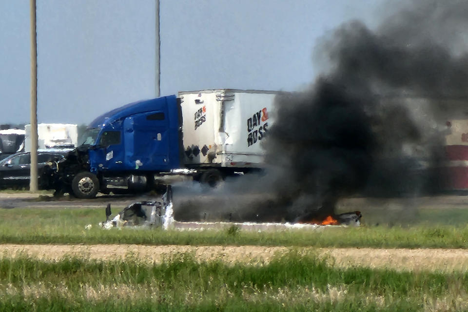 Smoke comes out of a car following a road accident that left 15 dead near Carberry, west of Winnipeg, Canada on June 15, 2023. At least 15 people died June 15, 2023 in a road accident in central Canada's Manitoba province, local media reported. Canadian police said on Twitter that officers were responding to a "mass casualty collision" near the town of Carberry, west of Winnipeg, and that first responders and other Royal Canadian Mounted Police units were on the scene. (Photo by Nirmesh VADERA / AFP) (Photo by NIRMESH VADERA/AFP via Getty Images)