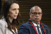 Pacific Peoples Minister Aupito William Sio looks at Prime Minister Jacinda Ardern speak during a post-Cabinet press conference on the 1970's dawn raids at Parliament in Wellington, New Zealand, Monday, June 14, 2021. New Zealand's government is formally apologizing for an immigration crackdown nearly 50 years ago in which Pacific people were targeted for deportation, often after early-morning home raids. (Mark Mitchell/NZ Herald via AP)