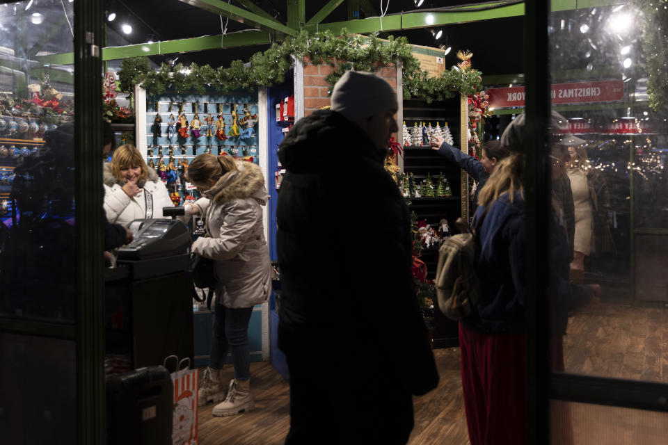 People shop for Christmas trinkets in Bryant Park's Winter Village, Tuesday, Nov. 15, 2022, in New York. After two years of pandemic holidays when people spent more dollars online, shoppers are back in force in stores and at holiday markets. Small businesses say it is beginning to feel a lot like Christmas, both emotionally and financially. (AP Photo/Julia Nikhinson)