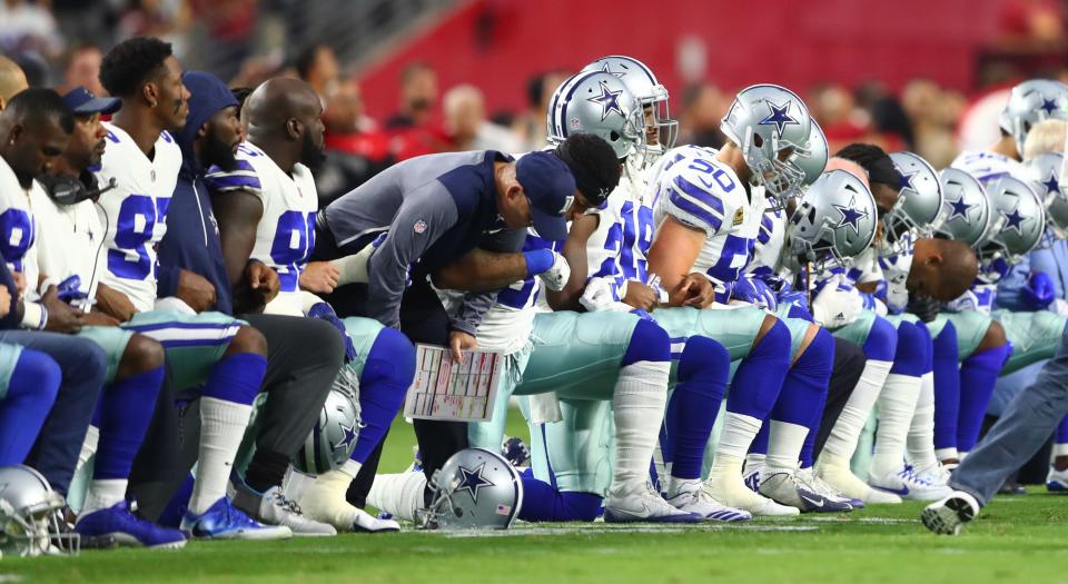 Dallas Cowboys players kneel together with their arms locked prior to the game against the Arizona Cardinals at University of Phoenix Stadium on Monday. (Photo: USA Today Sports / Reuters)