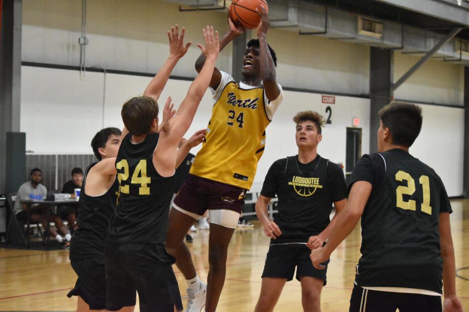 Bloomington North's JQ Roberts rises over the Loogootee defense to put up a shot during Bloomington Summer League play.