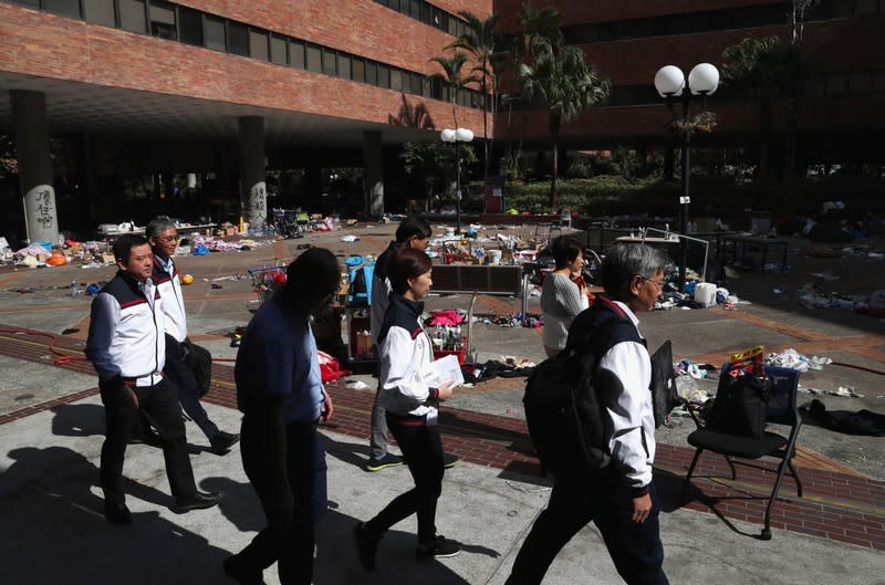 Staff members of the Hong Kong Polytechnic University leave following a news conference where they announced they had not found any protesters left on campus, in Hong Kong, China