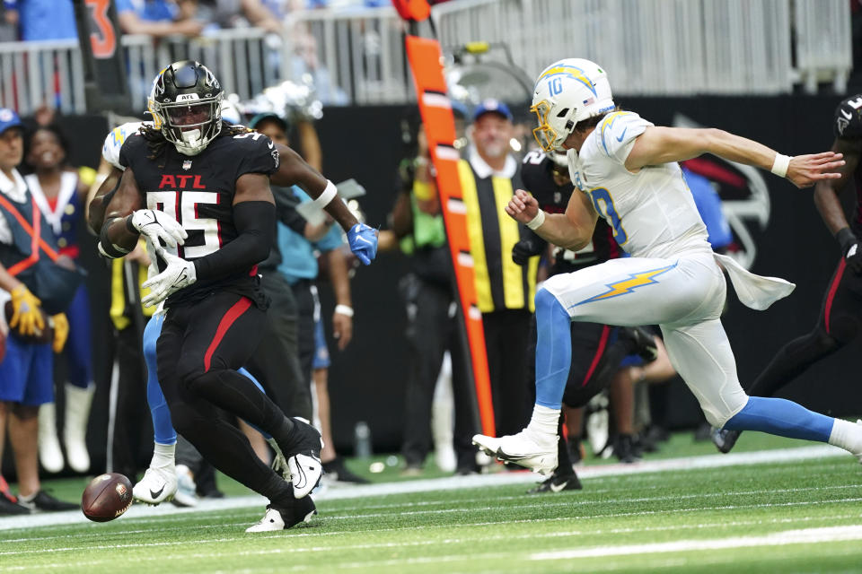 Atlanta Falcons defensive end Ta'Quon Graham (95) fumbles the ball in front of Los Angeles Chargers quarterback Justin Herbert (10) during the second half of an NFL football game, Sunday, Nov. 6, 2022, in Atlanta.  (AP Photo/John Bazemore)