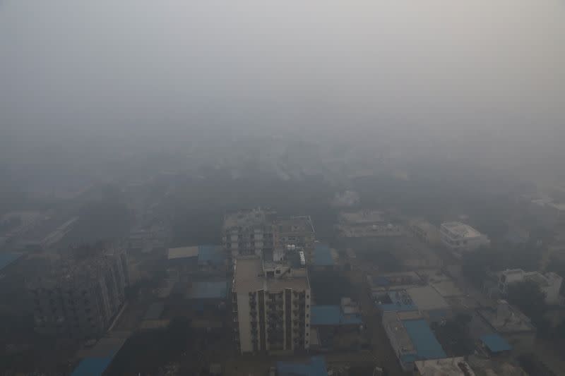 Residential buildings are seen shrouded in smog in Noida