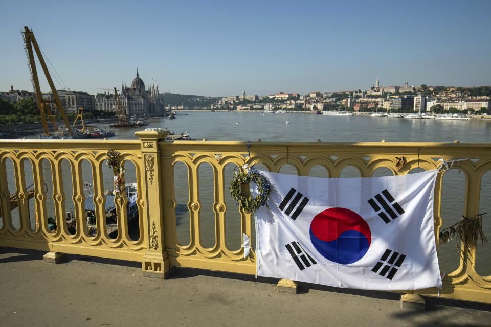 FILE - In this Saturday, June 8, 2019 file photo, a Korean flag adorns the rail of Margaret Bridge, the scene of the deadly boat accident in Budapest, Hungary. Hungarian police say that the deceased captain of the tour boat which sank after colliding with a river cruise ship on the Danube River was not to blame for the deadly incident. Twenty-eight people, mostly South Korean tourists, aboard the Hableany (Mermaid) sightseeing boat died after their vessel collided with the Viking Sigyn river cruise ship on May 29, 2019. The remains of a South Korean tourist have yet to be recovered (Balazs Mohai/MTI via AP, file)