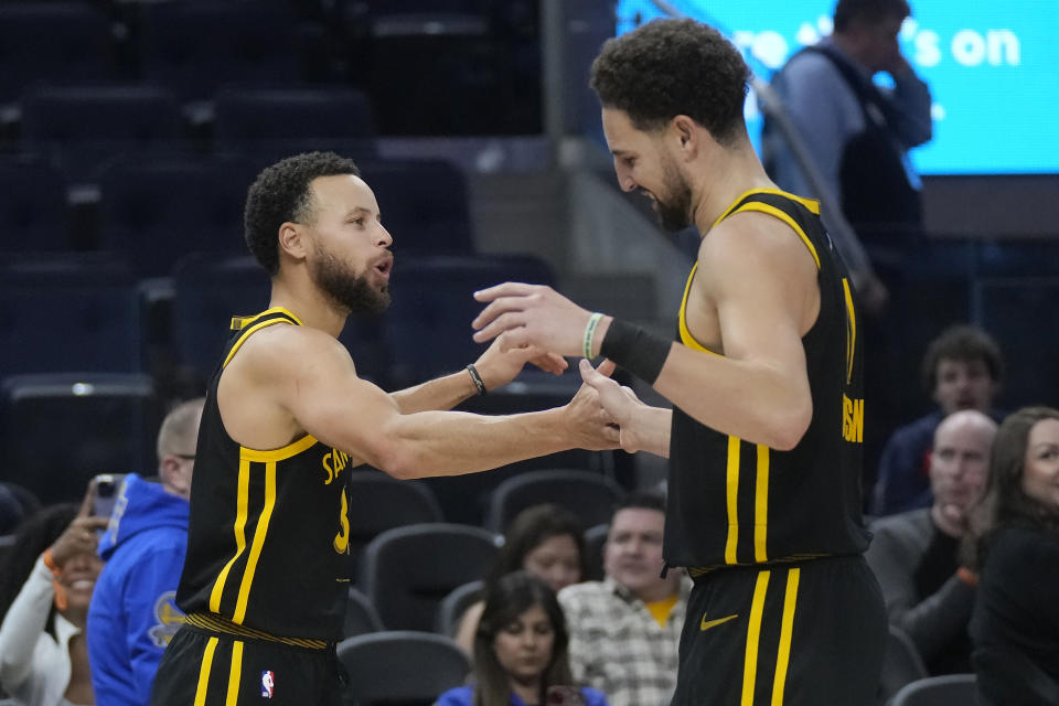 Golden State Warriors guard Stephen Curry, left, celebrates with guard Klay Thompson during the second half of the team's NBA basketball game against the Portland Trail Blazers in San Francisco, Saturday, Dec. 23, 2023. (AP Photo/Jeff Chiu)