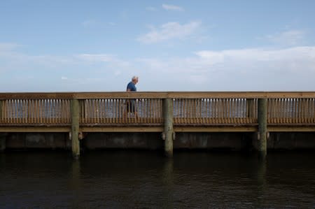 A man walks along a pier in Indian River at Parrish Park ahead of the arrival of Hurricane Dorian in Titusville