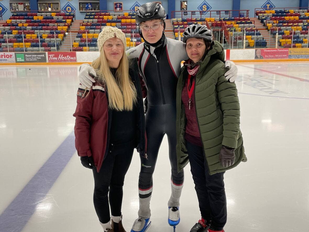 Noah Bolton stands on the ice at the Corner Brook Civic Centre after skating some practice laps. Coach Sharon Karn, left, and mother Nancy Bolton, right, are accompanying him to the 2023 Canada Winter Games. (James Grudić/CBC - image credit)