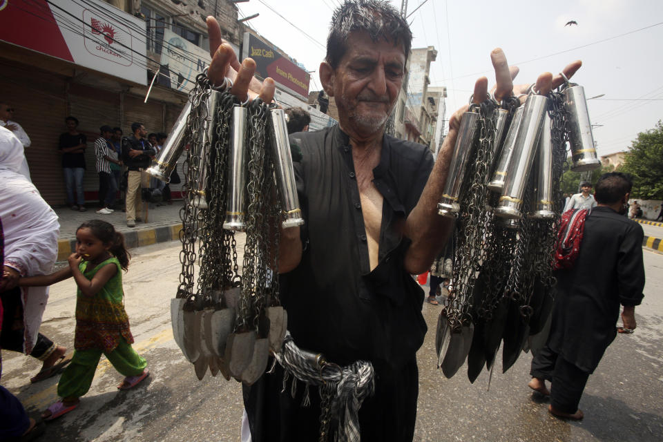 A Shiite Muslim sells knifes and chains during a procession to mark Ashoura, in Peshawar, Pakistan, Friday, July 28, 2023. Ashoura is the Shiite Muslim commemoration marking the death of Hussein, the grandson of the Prophet Muhammad, at the Battle of Karbala in present-day Iraq in the 7th century. (AP Photo/Mohammad Sajjad)