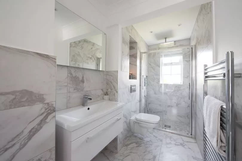 A general interior view of a wetroom bathroom tiled in grey marble.