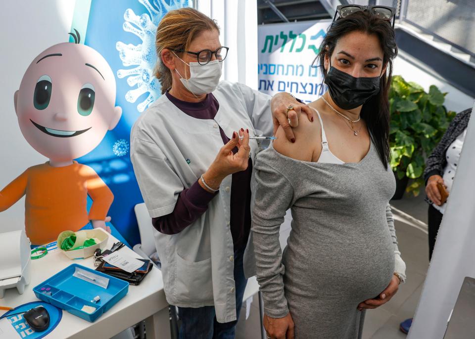 A health worker administers a dose of the Pfizer-BioNtech vaccine to a pregnant woman in Israel. Source: Getty