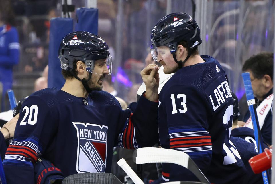 NEW YORK, NEW YORK - MARCH 17: Chris Kreider #20 of the New York Rangers shares smelling salts with Alexis Lafreniere #13 prior to the game against the New York Islanders at Madison Square Garden on March 17, 2024 in New York City.