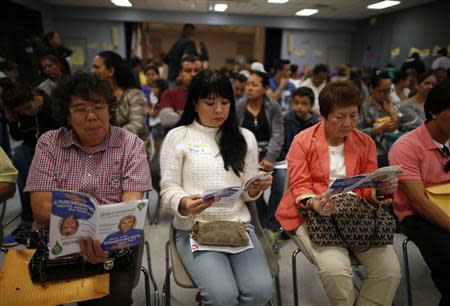 People wait in line at a health insurance enrollment event in Cudahy, California March 27, 2014. REUTERS/Lucy Nicholson