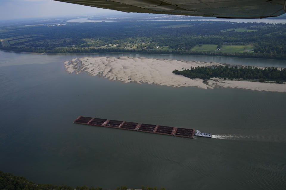 In this aerial photo, a tugboat pushing barges navigates around a sandbar during low water levels on the Mississippi River between Baton Rouge, La., and Reserve, La., in Livingston Parish, La., Thursday, Sept. 14, 2023. (AP Photo/Gerald Herbert)