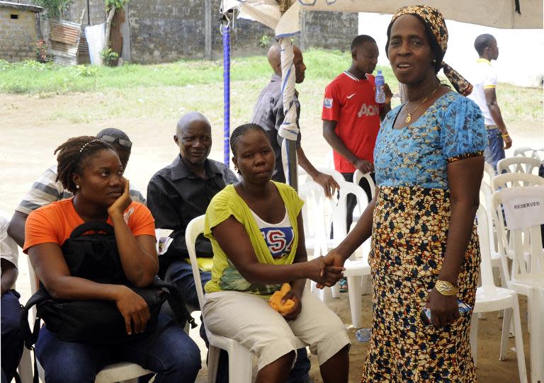 Beatrice Yordolo, declared the last survivor of Ebola, shakes hands with family during a visit by the director of the World Health Organization for the Africa region, Matshidiso Moeti to Zuma Town, on the outskirts of Monrovia, on April 22, 2015